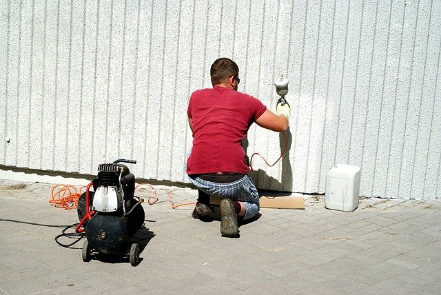 外壁塗装している男性